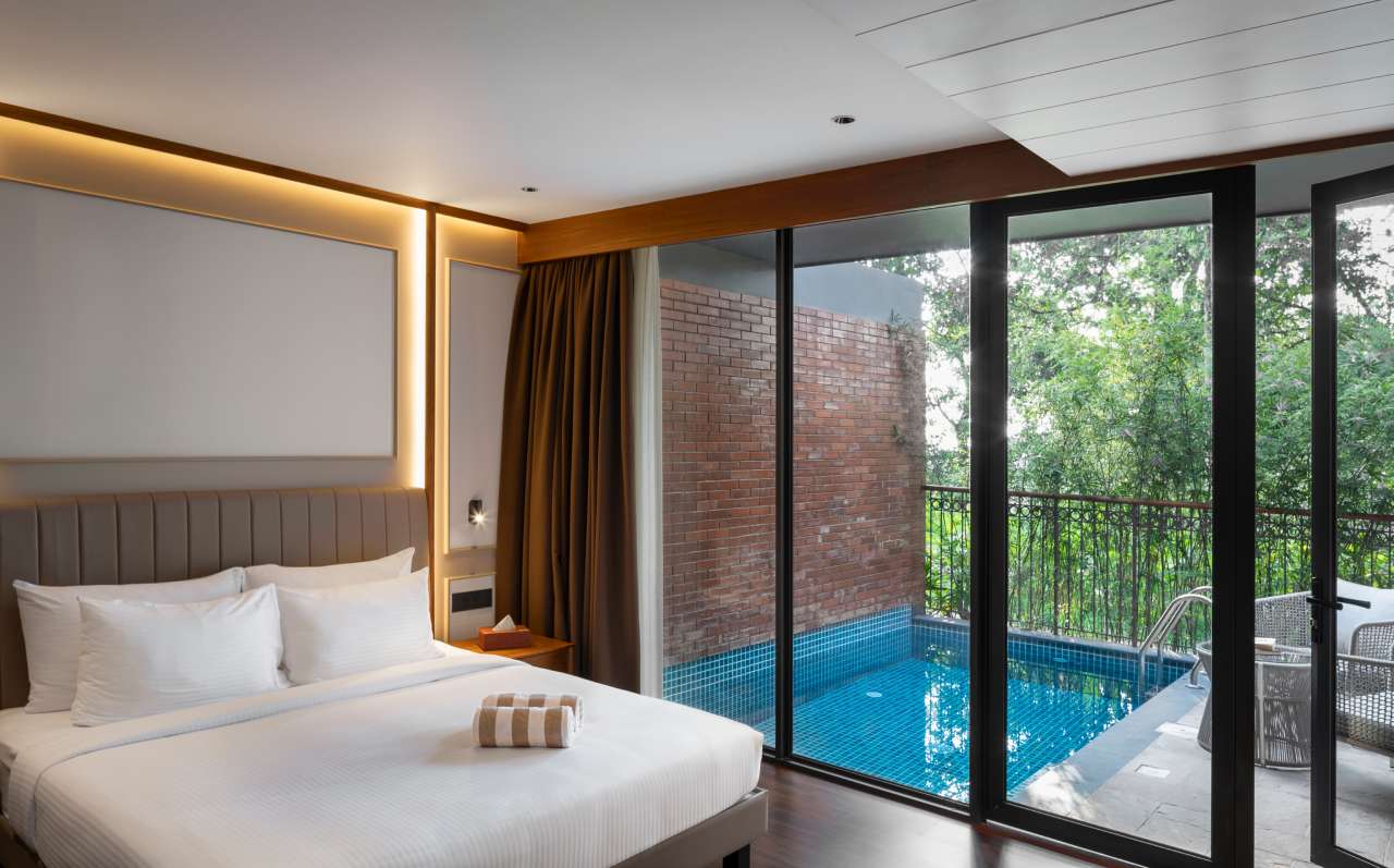 “Luxury pool-facing honeymoon bedroom at Lords 83 Resort in Wayanad with elegant interiors and direct access to the swimming pool.”