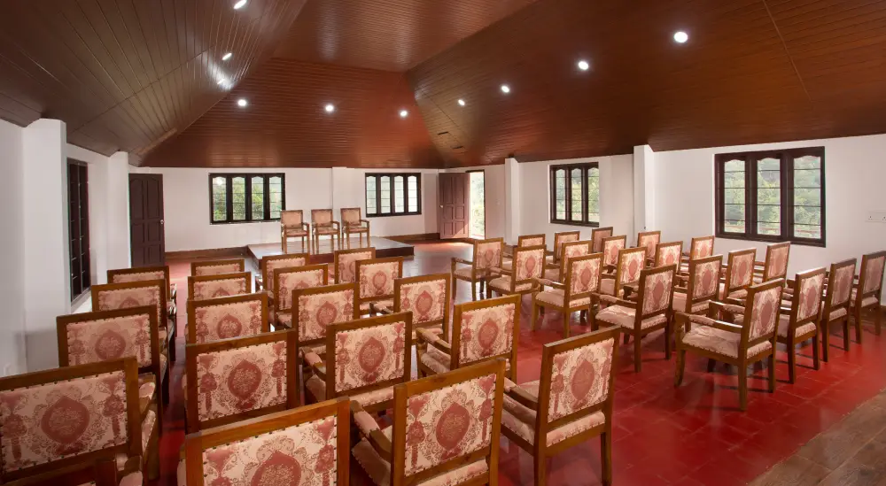 Conference hall in Munnar at Heaven Inn Resort with modern seating, projector setup, and serene hill surroundings