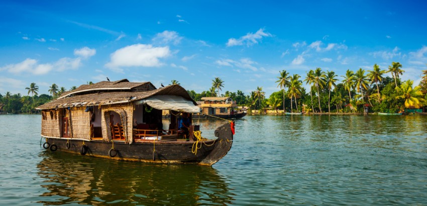 Scenic view of Alleppey, Kerala's popular tourist destination, featuring tranquil backwaters, lush coconut palms, and traditional houseboats.