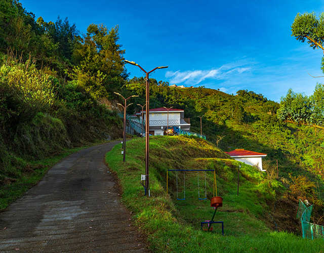 Warmth Hill Crest in Kodaikanal overlooking a breathtaking valley, featuring elegant hill-view rooms, scenic mountain landscapes, clear blue skies, and a peaceful natural setting.