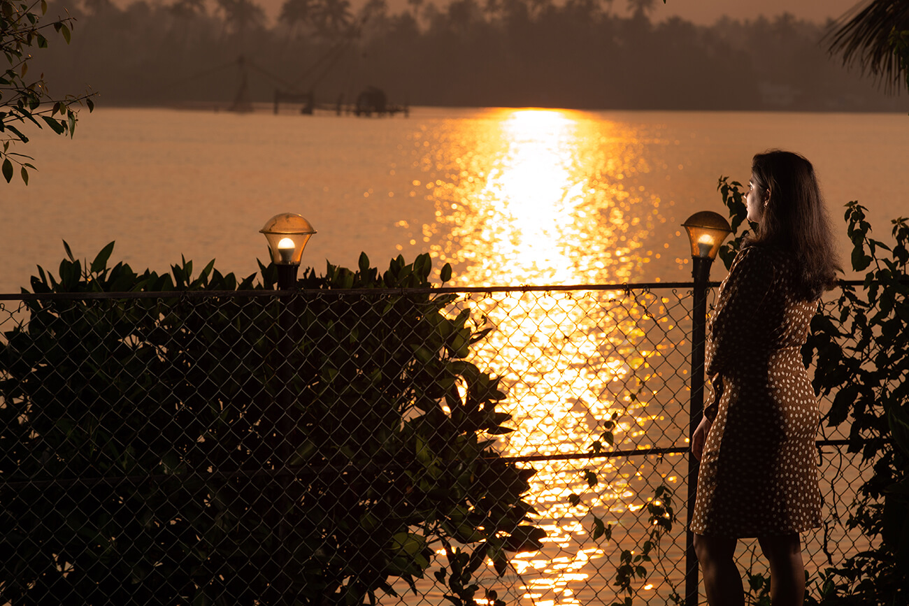 Scenic riverside view at Akanta Ayurvedic Resort in Kerala with tranquil backwaters, lush greenery, and golden sunset reflections