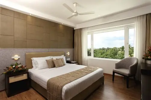 Executive Double room at Sugar Business Hotel, a hotel near Lakeshore Hospital Kochi, with double bed and green window view